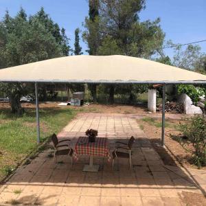 a picnic table with two chairs under a tent at Villa Despina in Saint Minas