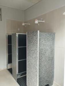 a bathroom with two glass doors in a room at Nostra Cuesta Hostel in Botucatu