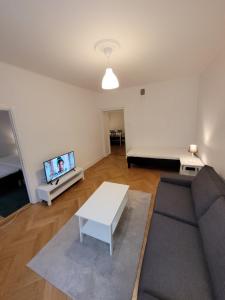 a living room with a couch and a tv at Home Inn PLG19 in Stockholm