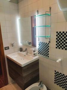 ein Badezimmer mit einem Waschbecken, einem Spiegel und einem WC in der Unterkunft Vatican Heart Leone Apartment at Roman Terrace in Rom