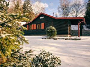 eine kleine Hütte mit rotem Dach im Schnee in der Unterkunft Privátní chata Dori se saunou v ceně in Kouty