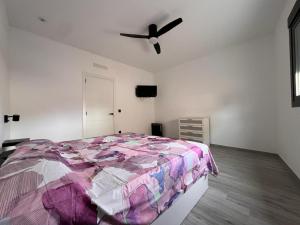 um quarto com uma cama e uma ventoinha de tecto em Casa del Pueblo em Montichelvo