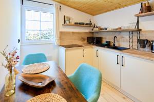 eine Küche mit einem Holztisch und blauen Stühlen in der Unterkunft Privátní chata Dori se saunou v ceně in Kouty