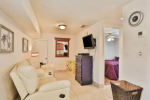 a living room with a white couch and a tv at Summer Sands Lodge U1 in Flagler Beach