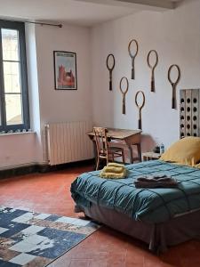 1 dormitorio con 1 cama, mesa y sillas en Chez Estelle Le SOL en Tourouzelle