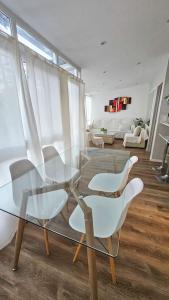 una mesa de cristal y sillas en la sala de estar. en Departamento PH en Martinez en Martínez