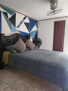 a bedroom with a bed with a geometric wall at Downtown Montezuma Hostel in Montezuma