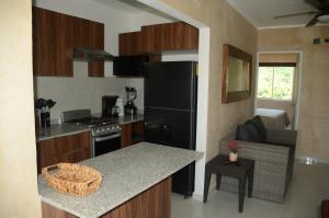 a kitchen with a black refrigerator and a counter top at Casa Parota Manzanillo in Manzanillo