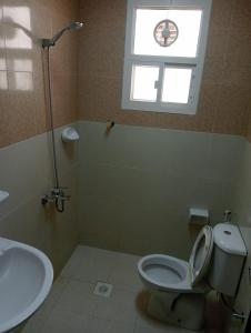 ein Bad mit einem WC, einem Waschbecken und einem Fenster in der Unterkunft JANDOUL SALALAH جندول صلاله in Salalah