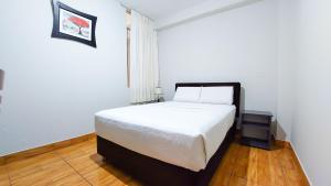 ein Schlafzimmer mit einem weißen Bett in einem Zimmer in der Unterkunft Samaná Hs in Tacna