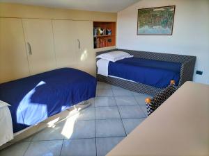1 dormitorio pequeño con 2 camas y mesa en Una vedetta sul mare, en SantʼAgata sui Due Golfi