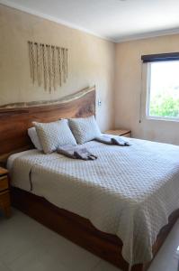 a bedroom with a large bed with a wooden headboard at Casa Parota Manzanillo in Manzanillo