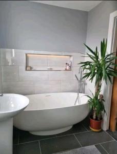 Un baño con bañera blanca y lavabo. en Family home, en Johnston 5 fotos más