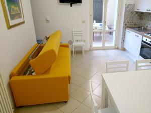 a living room with a yellow couch and a table at Grottammare mon amour Lori, con cortile privato in Grottammare