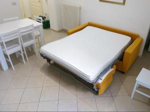 a bed sitting in a room next to a table at Grottammare mon amour Lori, con cortile privato in Grottammare