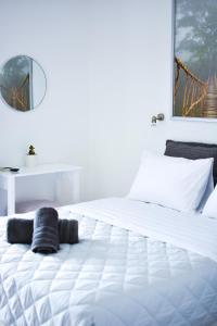 a white bed in a white room with a mirror at Daphne's studio 2 in Skiathos