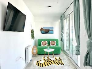 雅典Walk into Dream of Acropolis 6的客厅里有一张绿色的沙发和一张桌子