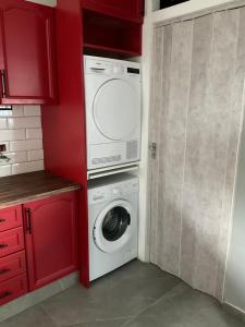 a washer and dryer in a kitchen with red cabinets at Casa vista mare in Corsanico-Bargecchia