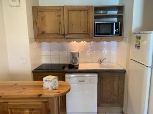 a kitchen with wooden cabinets and a white refrigerator at Résidence Le Grand Panorama - 2 Pièces pour 6 Personnes 13 in Saint-Gervais-les-Bains