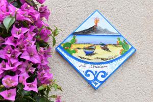 uma placa na parede com uma foto de uma praia em La Ciriciccia em Acireale
