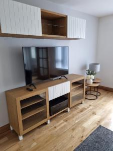 una sala de estar con un gran centro de entretenimiento con TV de pantalla plana en Sullatober House with hot tub and games room en Carrickfergus