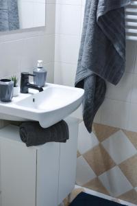 a white bathroom with a sink and towels at Daphne's studio 2 in Skiathos +15 photos