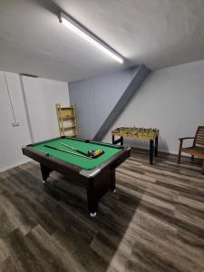 a room with a pool table and two chairs at Sullatober House with hot tub and games room in Carrickfergus