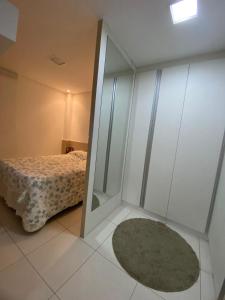 ein Schlafzimmer mit einem Spiegel, einem Bett und einem Teppich in der Unterkunft apt são joão de campina in Campina Grande