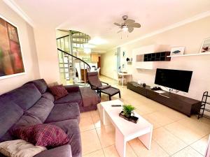 a living room with a purple couch and a tv at Charming 3 bedroom apartment in Playa de San Juan
