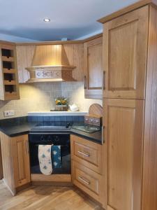 una cucina con armadi in legno e piano cottura. di Sullatober House with hot tub and games room a Carrickfergus