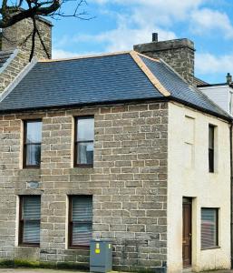 a brick house with a black roof at Argyle House Wick in Wick