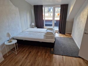a bedroom with a bed and a large window at Home Inn HVG54 in Stockholm