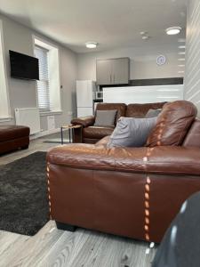 uma sala de estar com um sofá de couro castanho em Argyle House Wick em Wick
