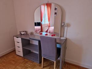 a desk with a mirror and a chair in a room at La casa de los viajeros in Vevey