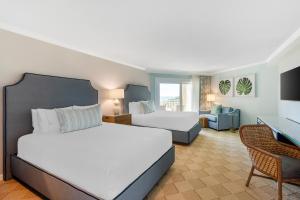 ヒルトン・ヘッド・アイランドにあるOmni Hilton Head Oceanfront Resortのベッドルーム1室(ベッド2台付)、リビングルームが備わります。