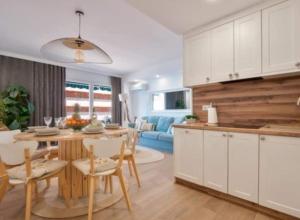 kuchnia i salon ze stołem i krzesłami w obiekcie Apartamento Antonio with sea view,Torrevieja,50 m from Playa Acequion plus swimming pool w mieście Torrevieja