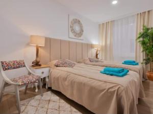 pokój hotelowy z dwoma łóżkami i krzesłem w obiekcie Apartamento Antonio with sea view,Torrevieja,50 m from Playa Acequion plus swimming pool w mieście Torrevieja +27 zdjęć