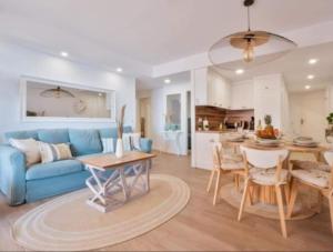 salon z niebieską kanapą i stołem w obiekcie Apartamento Antonio with sea view,Torrevieja,50 m from Playa Acequion plus swimming pool w mieście Torrevieja
