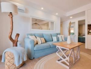 salon z niebieską kanapą i stołem w obiekcie Apartamento Antonio with sea view,Torrevieja,50 m from Playa Acequion plus swimming pool w mieście Torrevieja