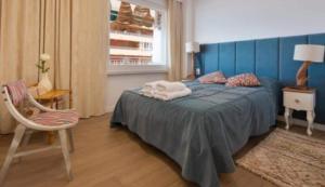 sypialnia z łóżkiem, krzesłem i oknem w obiekcie Apartamento Antonio with sea view,Torrevieja,50 m from Playa Acequion plus swimming pool w mieście Torrevieja