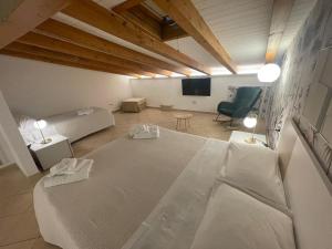 - un salon avec un grand lit et une chaise dans l'établissement Albergo Perseo, à Portopalo di Capo Passero