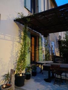 un patio al aire libre con una mesa y macetas en Chez Estelle Le SOL en Tourouzelle