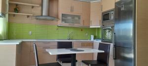 a kitchen with a refrigerator and a table with chairs at ioli in Olympiaki Akti