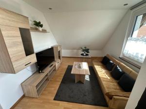 ein Wohnzimmer mit einem Sofa und einem Tisch in der Unterkunft 2,5 Raum Ferienwohnung möbliert Dachgeschoss Niederorschel in Niederorschel