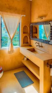 W łazience znajduje się umywalka i lustro. w obiekcie Casa Maridadi w mieście Watamu