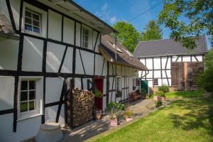 a white and black house with a yard at Haus Nr. 9 in Ruppichteroth