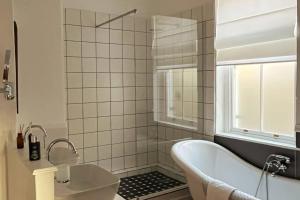 a white bathroom with a tub and a window at Stay at Molly in Prince Albert +73 photos