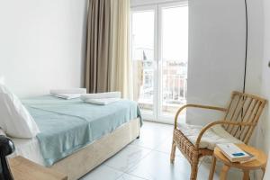 een slaapkamer met een bed, een stoel en een raam bij Queens suite in Thessaloniki