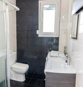 een badkamer met een toilet, een wastafel en een raam bij Queens suite in Thessaloniki