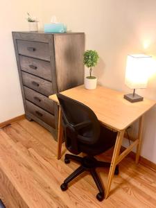 a desk with a lamp and a chair next to a dresser at The House Hotels - Erie Street 1 in Cuyahoga Falls